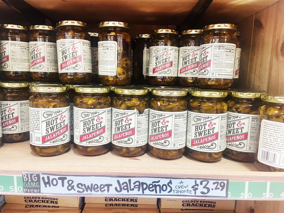 Clear jars of Trader Joe's hot and sweet jalapenos with white and red labels on them