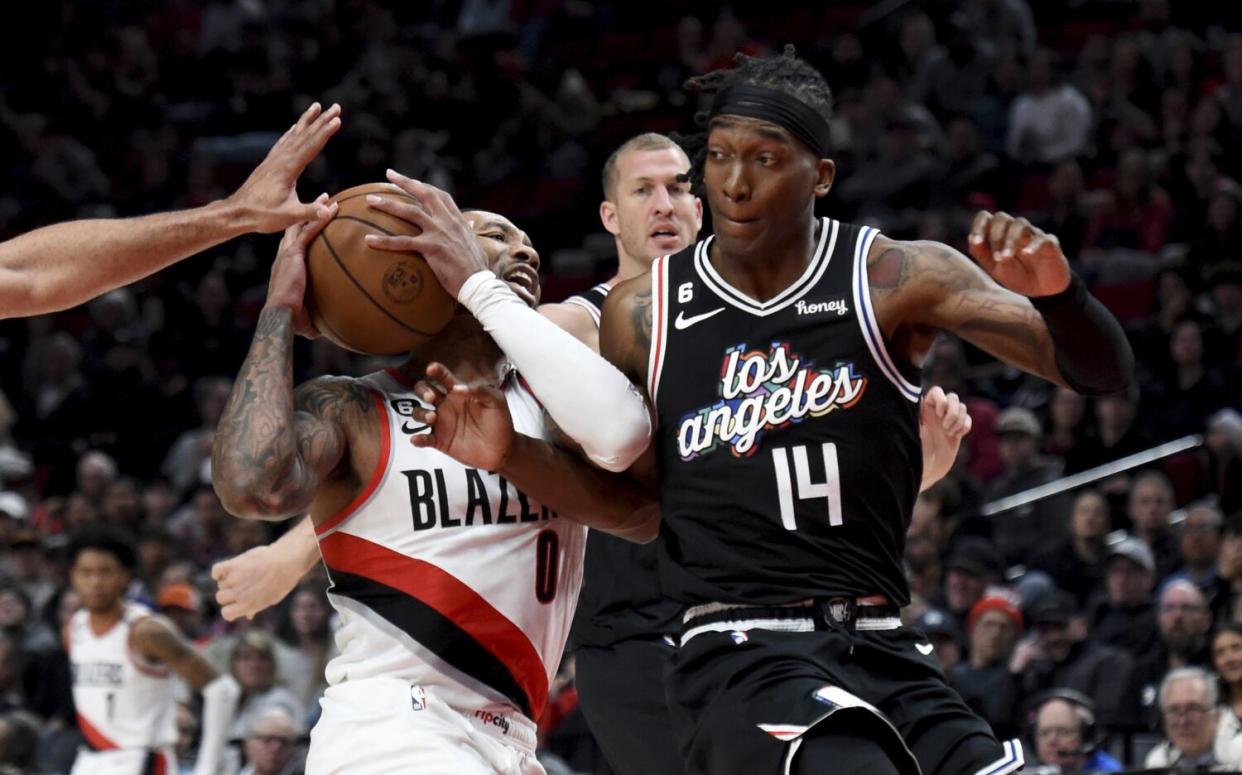 Portland Trail Blazers guard Damian Lillard, left, drives against Clippers guard Terance Mann.