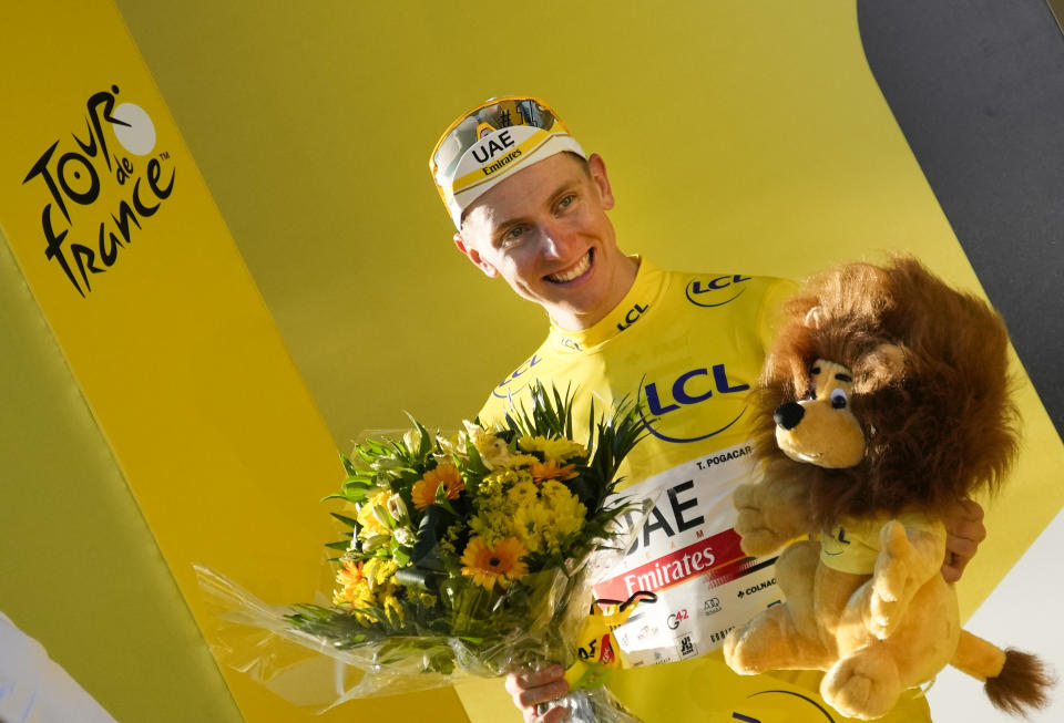 Tour de France winner Slovenia's Tadej Pogacar, wearing the overall leader's yellow jersey, celebrates on the podium after the twenty-first and last stage of the Tour de France cycling race over 108.4 kilometers (67.4 miles) with start in Chatou and finish on the Champs Elysees in Paris, France,Sunday, July 18, 2021. (AP Photo/Christophe Ena)