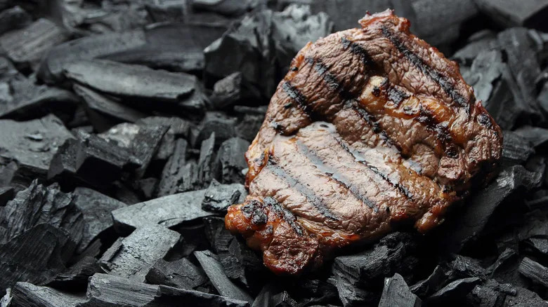 steak cooking on coals