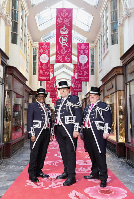 EDITORIAL USE ONLY
(Left to right) Beadle’s Fred Ikwele, Duk Goraj and Mark Lord at Burlington Arcade as it unveils a celebratory installation to mark the Coronation of His Majesty The King and Her Majesty The Queen Consort. Picture date: Tuesday April 18, 2023. PA Photo. Designed by Amanda Davis from AD Events, the installation is made up of 55 flags and a 180 metres long carpet running the entire length of the 203-year-old arcade from Piccadilly through to Burlington Gardens. Picture credit should read: Matt Alexander/PA Wire.