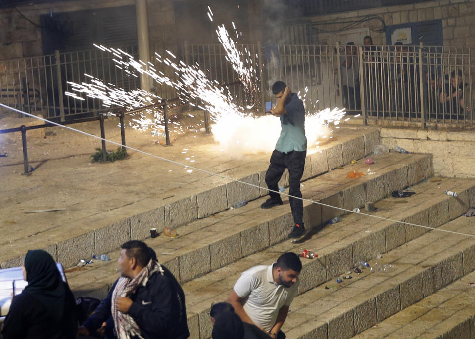 Palestinians run from stun grenades fired by Israeli police officers during clashes at Damascus Gate just outside Jerusalem's Old City, Saturday, May 8, 2021. (AP Photo/Oded Balilty)