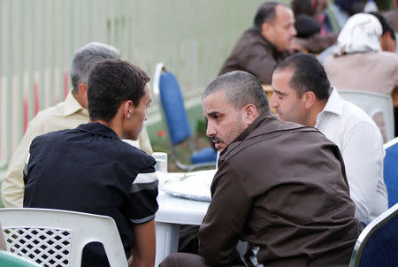 Ahmad Daqamseh, a Jordanian soldier convicted of killing seven Israeli schoolgirls on March 13, 1997, speaks with his son at Um Alluol prison in the city of Mafraq, Jordan, July 30, 2013. Picture taken July 30, 2013. REUTERS/Muhammad Hamed