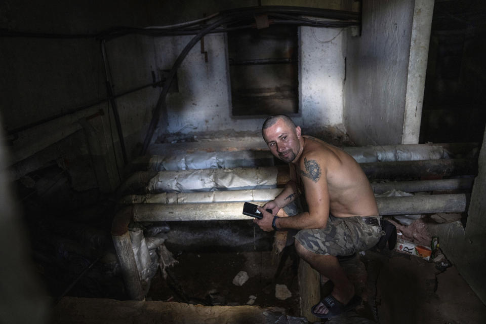 FILE - Viktor Lazar, 37, collects water from a pumping system in the basement of his apartment house in Saltivka district after Russian attacks in Kharkiv, Ukraine, July 5, 2022. As Russia's invasion of Ukraine grinds into its fifth month, some residents close to the front lines remain in shattered and nearly abandoned neighborhoods. One such place is Kharkiv's neighborhood of Saltivka, once home to about half a million people. Only perhaps dozens live there now, in apartment blocks with no running water and little electricity. (AP Photo/Evgeniy Maloletka, File)