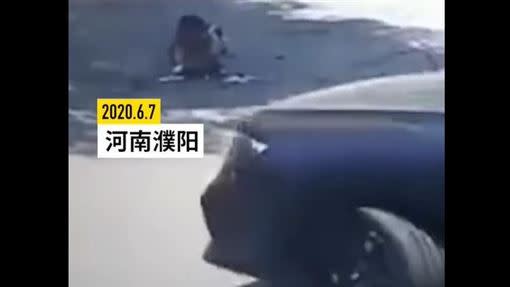 男童蹲在社區道路上，駕駛疑似視線死角，沒注意到男童在車道上，將期輾壓過。（圖／翻攝自梨視頻）