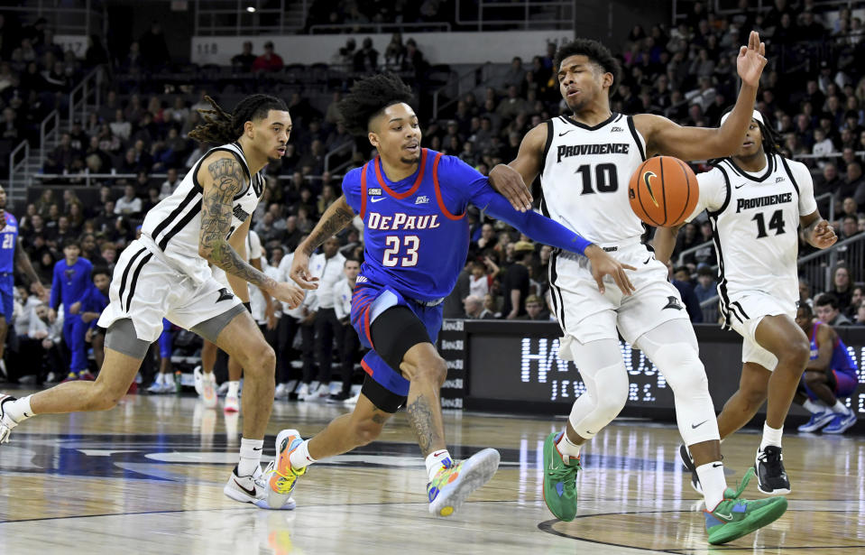 DePaul's Caleb Murphy passes the ball as Providence's defense, including Noah Locke (10), chases during the first half of an NCAA college basketball game, Saturday, Jan. 21, 2023, in Providence, R.I. (AP Photo/Mark Stockwell)