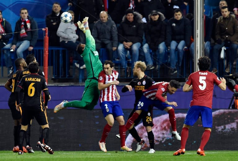 Galatasaray's goalkeeper Fernando Muslera (top) tries to stop a ball next to Atletico Madrid's defender Diego Godin (4th R) during a UEFA Champions League match at the Vicente Calderon stadium in Madrid on November 25, 2015