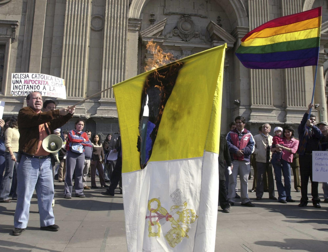 FILE - Rolando Jimenez, leader of a Chilean gay rights organization, holds a flaming Vatican flag during a protest by gay activists against the Roman Catholic Church's rejection of same-sex marriages, in front of a cathedral in Santiago, Chile, in this Friday, Aug. 15, 2003 file photo. In an interview with The Associated Press at The Vatican, Tuesday, Jan. 24, 2023, Pope Francis acknowledged that Catholic bishops in some parts of the world support laws that criminalize homosexuality or discriminate against the LGBTQ community, and he himself referred to homosexuality in terms of "sin." But he attributed attitudes to cultural backgrounds and said bishops in particular need to undergo a process of change to recognize the dignity of everyone. (AP Photo/Santiago Llanquin)