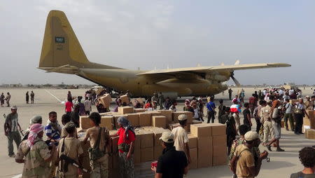 Workers and Southern Resistance fighters unload an aid shipment from a Saudi military cargo plane at the international airport of Yemen's southern port city of Aden July 23, 2015. REUTERS/Stringer