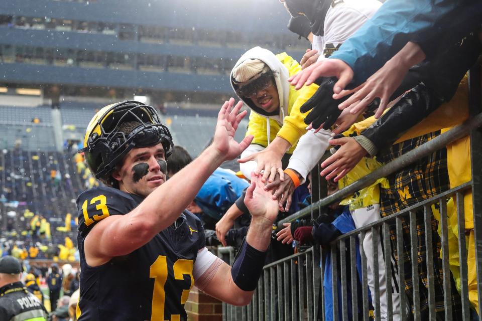Michigan quarterback Jack Tuttle high-fives players after U-M's 52-7 win over Indiana on Saturday, Oct. 14, 2023, in Ann Arbor.