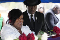 Civil rights attorney Ben Crump, right, looks on as Bettersten Wade, mother of Dexter Wade, cries as she leaves a rose on her son's coffin in Jackson, Miss. Monday, Nov. 20, 2023. Wade, a 37-year-old man who died after being hit by a Jackson police SUV driven by an off-duty officer, was initially buried in a paupers cemetery without any notification to his family. (AP Photo/Rogelio V. Solis)
