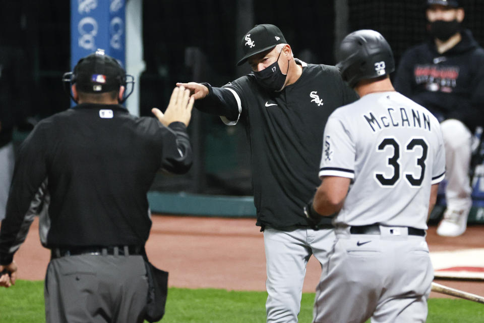 Chicago White Sox manager Rick Renteria, center, is ejected from a baseball game by umpire Dan Bellino for arguing after James McCann (33) was called out on strikes during the ninth inning Monday, Sept. 21, 2020, in Cleveland. (AP Photo/Ron Schwane)