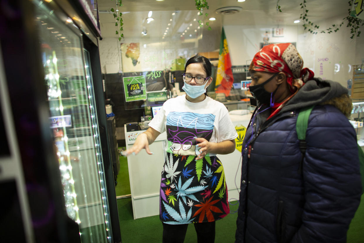 A customer receives information about cannabis as she buys THC leaves at the Weed World store on March 31, 2021, in Midtown New York. - New York Governor Andrew Cuomo signed legislation legalizing recreational marijuana on March 31. 2021, with a large chunk of tax revenues from sales set to go to minority communities. New York joins 14 other US states and the District of Columbia in permitting cannabis after lawmakers in both state chambers, where Cuomo's Democratic Party holds strong majorities, backed the bill on March 30. (Photo by Kena Betancur / AFP) (Photo by KENA BETANCUR/AFP via Getty Images)