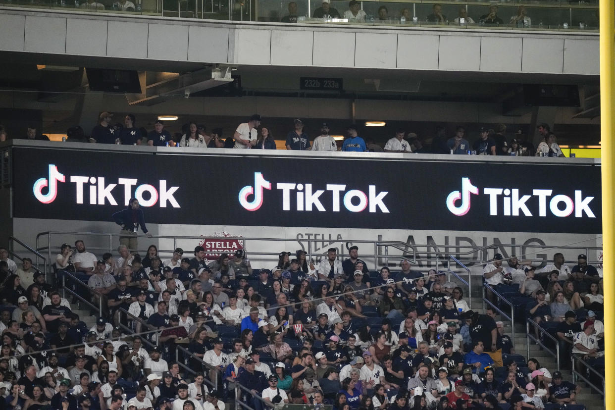 Fans stand near a TikTok logo during the fourth inning of a baseball game between the New York Yankees and the Minnesota Twins Friday, April 14, 2023, in New York. (AP Photo/Frank Franklin II)