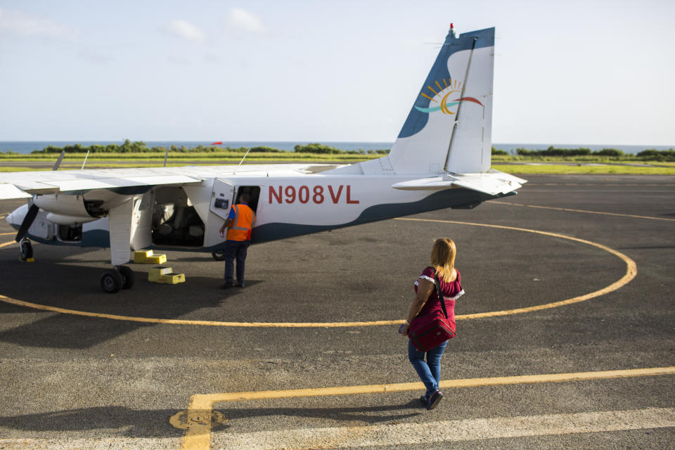 Leyla Rivera Acosta walks toward the small eight-seat aircraft that transports her and other dialysis patients in Vieques three times a week to the main island to receive their life-saving treatment. (Photo: Dennis M. Rivera Pichardo for HuffPost)