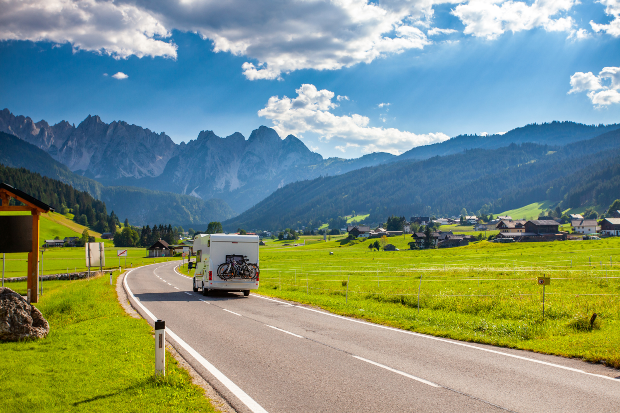 RV on Road Going Through Austria Alps During Summer