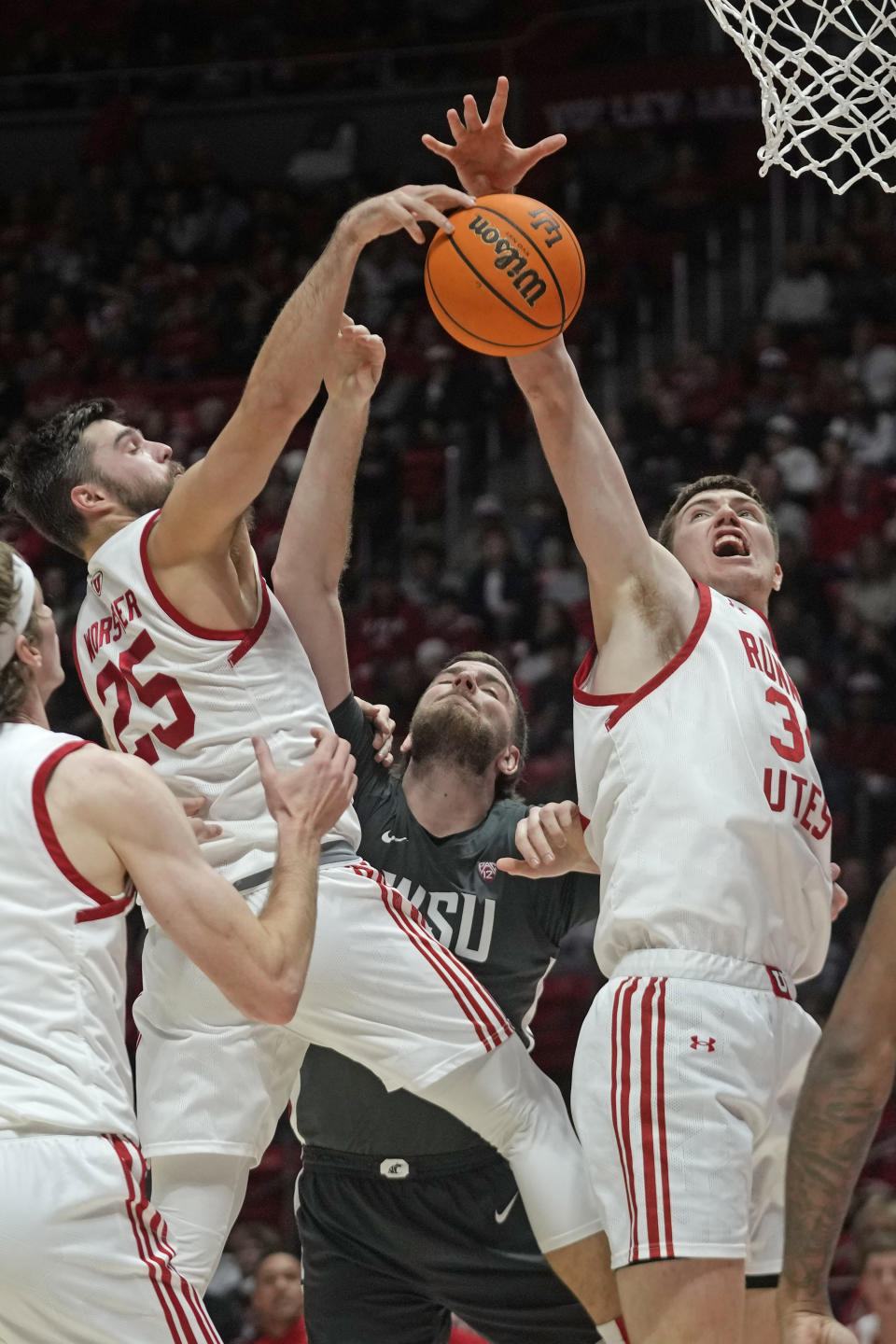 Washington State forward Oscar Cluff, center, battles with Utah's Rollie Worster (25) and Lawson Lovering (34) during the first half of an NCAA college basketball Friday, Dec. 29, 2023, in Salt Lake City. (AP Photo/Rick Bowmer)