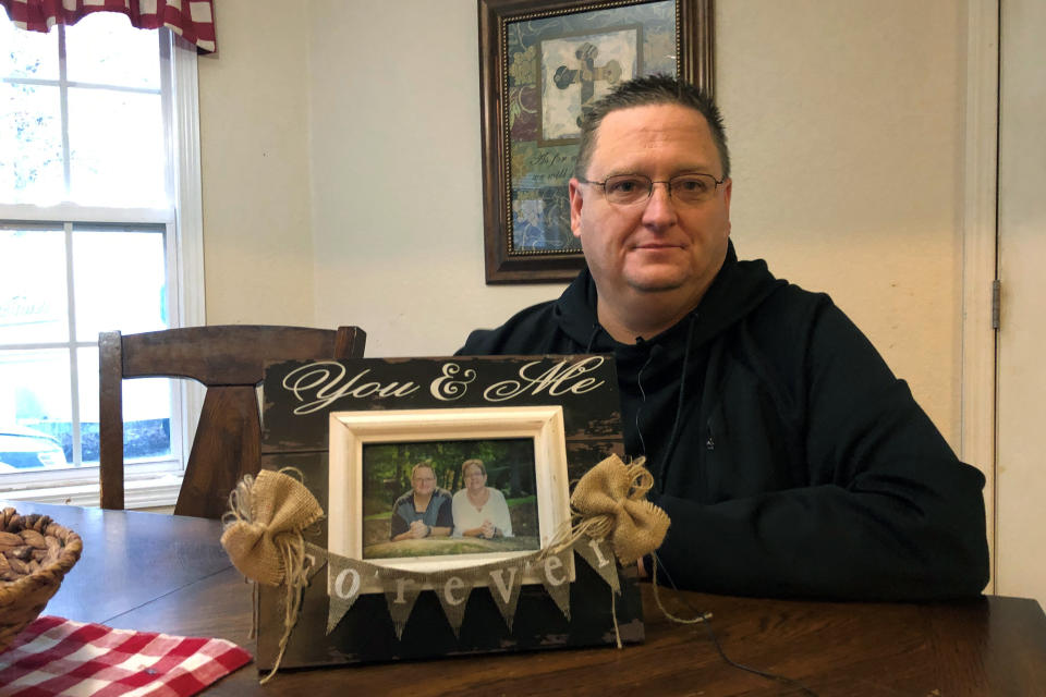 Keith Michael holds a photo on Friday, Nov. 13, 2020, in Jonesboro, Ark., of him and his wife, Susanne, a fourth-grade teacher who died from coronavirus. “She just basically would eat, sleep and drink teaching. She loved it,” said her husband. (AP Photo/Adrian Sainz)