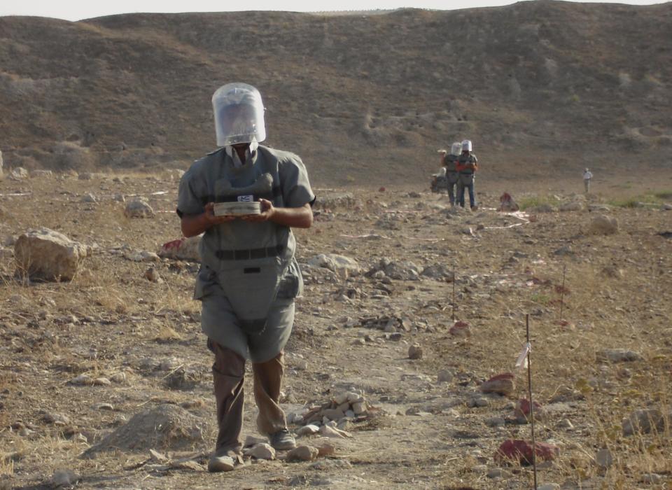 FILE - In this June 17, 2010 file photo land mine experts work in mined land in the Karkemish archaeological site at the Turkey-Syria border in Gaziantep province, Turkey. Starting in the 1950s, Turkish forces planted more than 600,000 U.S.-made "toe poppers" _ mines designed to maim, not kill _ and other land mines along much of its 900-kilometer (560-mile) border with Syria, which runs from the Mediterranean Sea to Iraq. The aim was to stop smugglers whose cheap black market goods undercut the Turkish economy and later to thwart Kurdish rebels from infiltrating Turkey's southeast. (AP Photo/File)