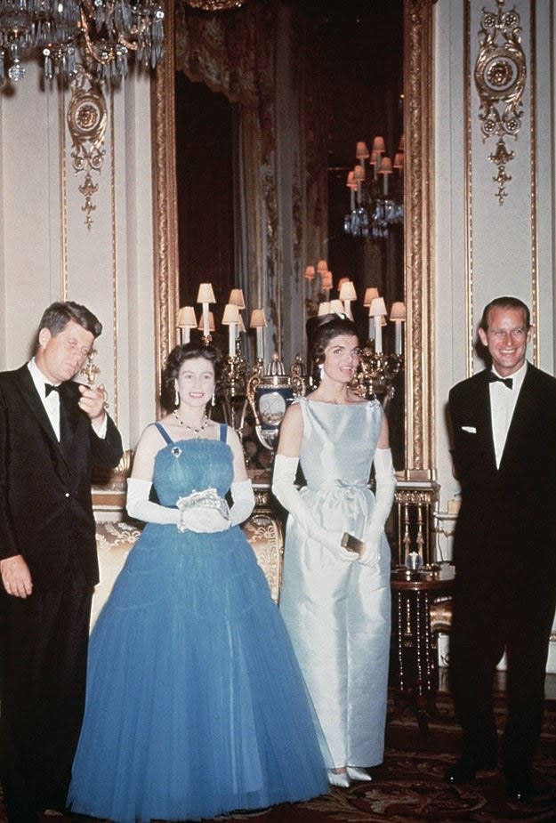The Queen in a puffy blue gown next to Jackie's light blue and sleek one