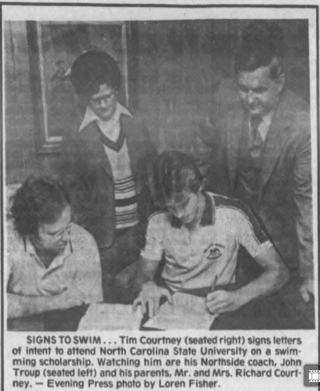 FILE -- Tim Courtney (seated right) signs letters of intent to attend North Carolina State University on a swimming scholarship.
