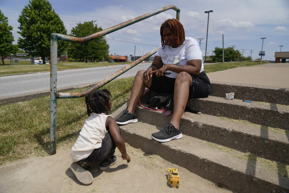 Toriana Hill sits outside a Red Cross shelter with her son Nassir Gladney, 3, and puppy Luna, Wednesday, May 31, 2023, in Davenport, Iowa. Hill and her son escaped from the sixth floor after their apartment building partially collapsed Sunday afternoon. Five residents of the same building remained unaccounted for Wednesday, and authorities feared at least two of them might be stuck inside rubble that was too dangerous to search. (AP Photo/Erin Hooley)