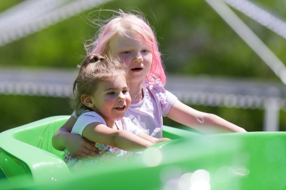 Amelia Otterbeck, 2, of Pleasant Hill, is held by her cousin Analia Torres, 4, of Des Moines, as they ride Leap Frogs during Adventureland's opening day of the 2022 season Saturday, May 14, 2022 in Altoona. 