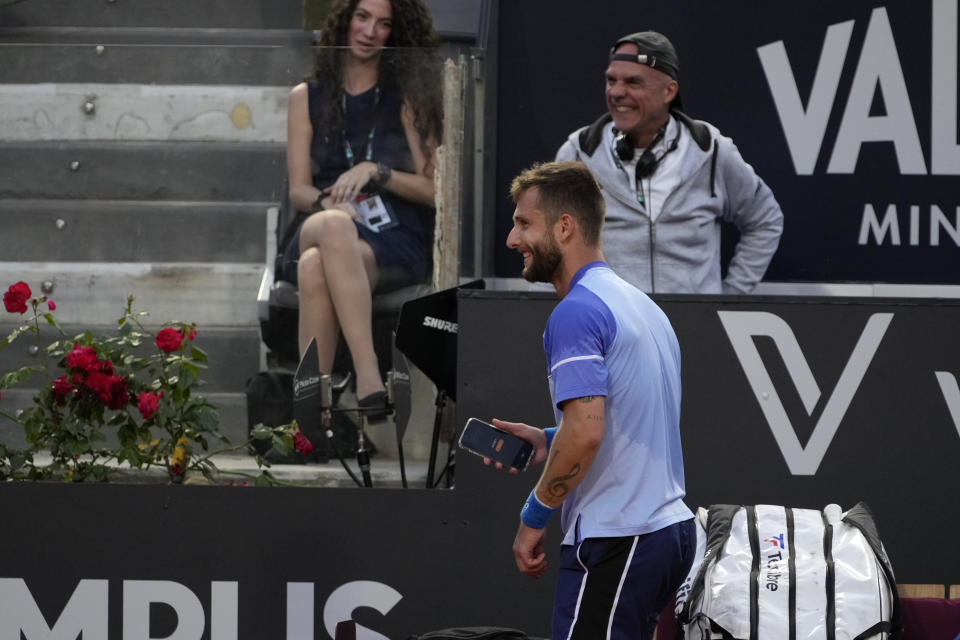 France's Corentin Moutet jokes with a cell phone during a match against Serbia's Novak Djokovic at the Italian Open tennis tournament in Rome, Friday, May 10, 2024. (AP Photo/Alessandra Tarantino)