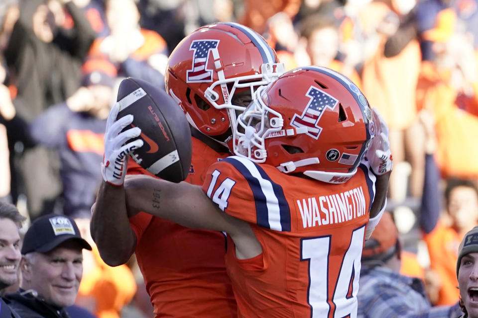 Illinois wide receiver Isaiah Williams, left, celebrates his game winning touchdown with wide receiver Casey Washington during the overtime period of an NCAA college football game against Indiana on Saturday, Nov. 11, 2023, in Champaign, Ill. Illinois won 48-45. (AP Photo/Charles Rex Arbogast)