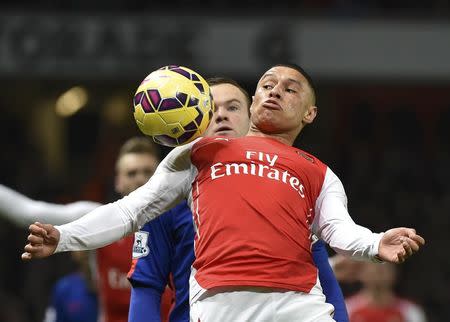 Manchester United's Wayne Rooney (REAR) is challenged Arsenal's Alex Oxlade-Chamberlain during their English Premier League soccer match at the Emirates Stadium in London November 22, 2014. REUTERS/Toby Melville