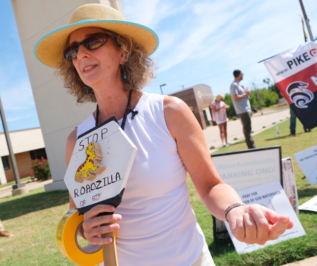 Tassie Katherine Hirschfeld talks with reporters at a protest outside of a fundraiser for Gov. Kevin Stitt. Members of Pike Off OTA, a group opposed to portions of the ACCESS turnpike expansion, protested the fundraiser Tuesday, Aug. 30, 2022, at the Association of Oklahoma General Contractors.