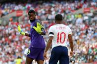 <p>Nigeria goalkeeper Francis Uzoho exchanges words with Raheem Sterling after he is booked for diving during </p>
