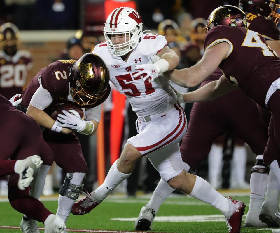 Wisconsin linebacker Jack Sanborn (57) sacks Minnesota quarterback Tanner Morgan during the fourth quarter of their game Nov. 27, 2021.