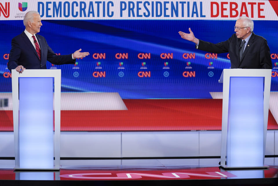 FILE - In this March 15, 2020, file photo former Vice President Joe Biden, left, and Sen. Bernie Sanders, I-Vt., right, participate in a Democratic presidential primary debate at CNN Studios in Washington. U.S. elections have been upended by the coronavirus pandemic. At least 13 states have postponed voting and more delays are possible as health officials warn that social distancing and other measures to contain the virus might be in place for weeks, if not months. (AP Photo/Evan Vucci, File)