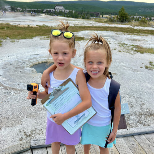 Erica Pickett’s twins Kinsley, left, and Adelyn completed a science project at the Old Faithful Geyser in Yellowstone National Park. (Erica Pickett)