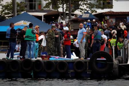 Rescuers wait at the dock after a tourist boat sank with 150 passengers in the Guatape reservoir, Colombia, June 25, 2017. REUTERS/ Fredy Builes