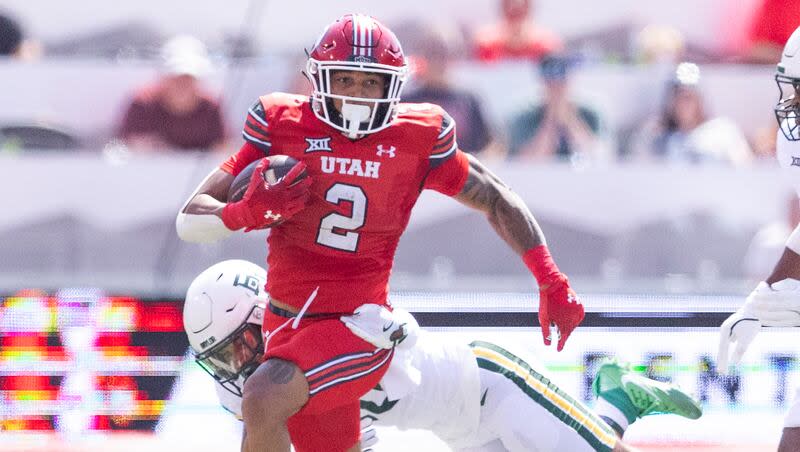 Utah Utes running back Micah Bernard (2) slips a tackle by Baylor Bears safety Devin Lemear (20) at Rice-Eccles Stadium on the campus of the University of Utah in Salt Lake City on Saturday, Sept. 7, 2024.