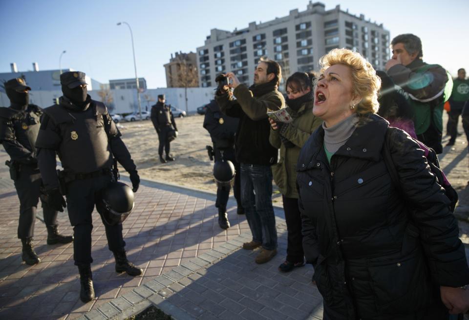 Anti-eviction activists shout slogans and hold one-month-old son Dilan after his family was evicted from their apartment in Madrid