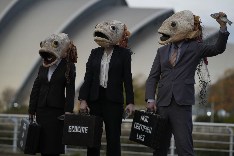 Campaigners from the environment group Ocean Rebellion wearing fish head masks take part in a protest stunt against the Marine Stewardship Council (MSC), on the fringes of the COP26 U.N. Climate Summit taking place in Glasgow, Scotland, Thursday, Nov. 4, 2021. (AP Photo/Alastair Grant)