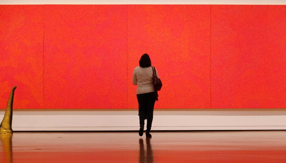 In this photo taken Tuesday, Oct. 9, 2012, a visitor looks closely at an acrylic painting by Yayoi Kasama (I Want To Live Forever, 2008) as part of one of two new exhibits featuring art exclusively by women at the Seattle Art Museum, in Seattle. Included in the exhibition is the only U.S. stop for an exhibit from the Pompidou Center in Paris, home of the modern art museum there, of painting, sculpture, drawing, photography and video. The exhibit runs through Jan. 13, 2013. (AP Photo/Elaine Thompson)