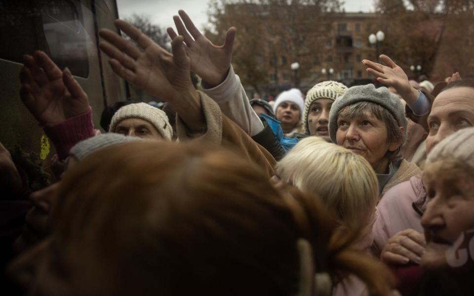 Residents crowd around a volunteer aid truck to receive, food and medical supplies in Kherson - Chris McGrath/Getty Images