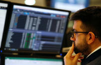 A trader works at his desk whilst screens show market data at CMC Markets in London, Britain, January 16, 2019. REUTERS/John Sibley