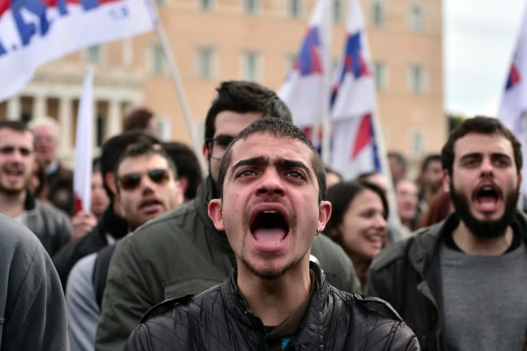 Demonstrators shout slogans beside the Greek parliament in Athens during a massive protest on February 4, 2016