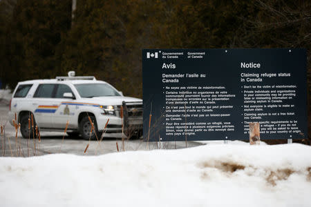 A Royal Canadian Mounted Police (RCMP) vehicle is seen near a sign at the US-Canada border in Lacolle, Quebec, Canada, February 14, 2018. REUTERS/Chris Wattie