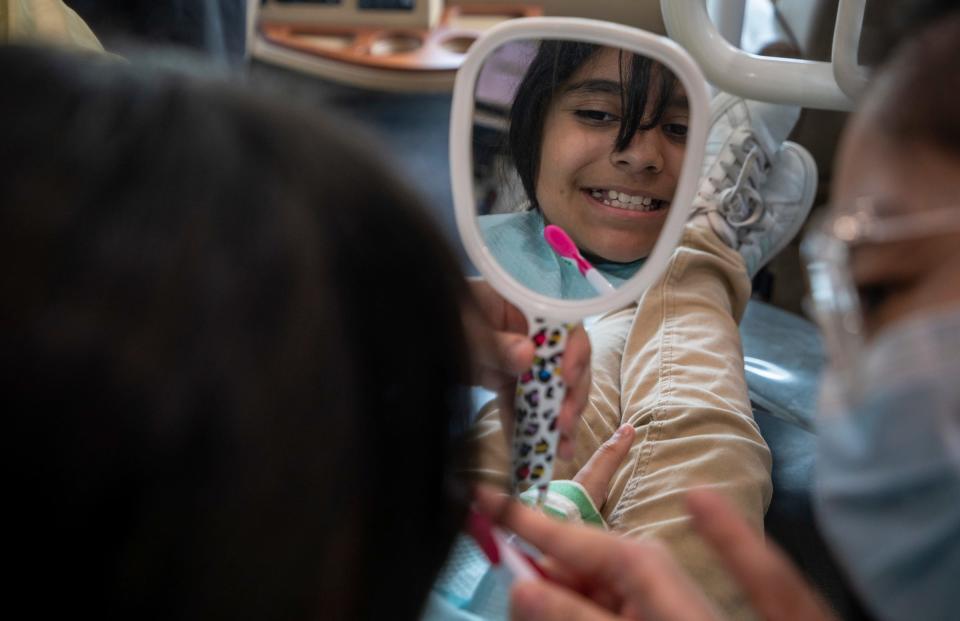 Jessica Oh, 33, a fourth-year dental student with the University of Detroit Mercy School of Dentistry Dental Clinic, demonstrates proper hygiene instructions to 10-year-old Milagro Fernandez-Rivera inside the Titans for Teeth Mobile Clinic at the Munger Elementary-Middle School in Detroit on April 26, 2023.