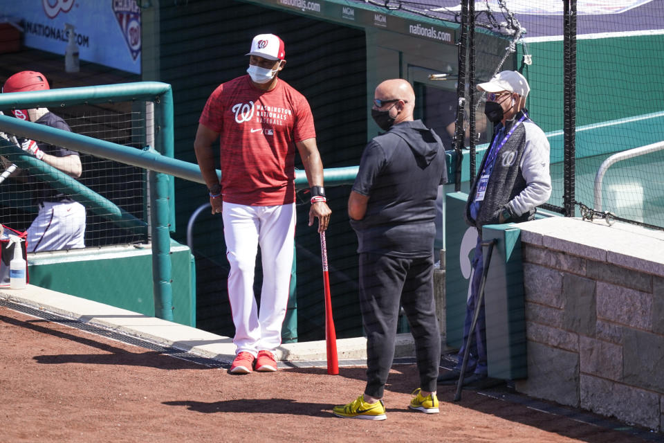 Washington Nationals manager Dave Martinez, left, general manager Mike Rizzo, and owner Mark Lerner watch the team during a baseball workout at Nationals Park, Monday, April 5, 2021, in Washington. The Nationals are scheduled to play the Braves on Tuesday. (AP Photo/Alex Brandon)