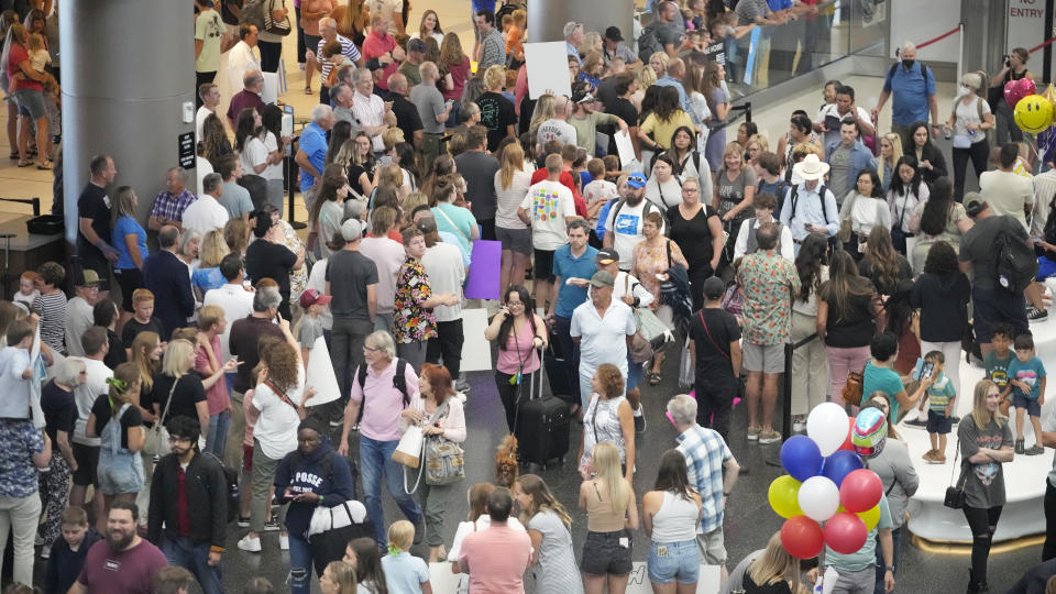 Travelers walk through crowds after arriving at the Salt Lake City International Airport Friday, June 30, 2023, in Salt Lake City. (AP Photo/Rick Bowmer)