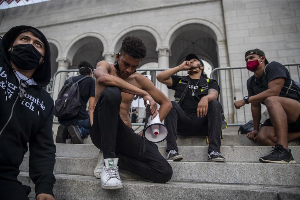 Marcus Owen, with bullhorn, leads a moment of silence for George Floyd as protesters gather outside L.A. City Hall.