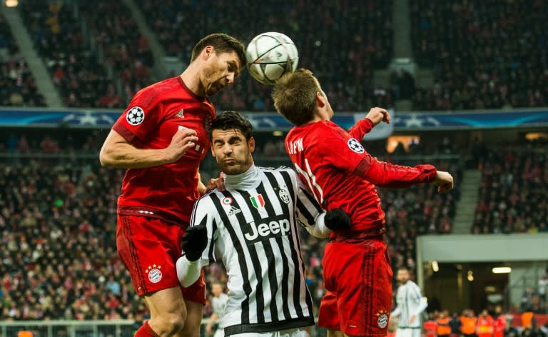 Bayern Munich's Xabi Alonso (L), Juventus' Mirko Vucinic (C) and Bayern Munich's Philipp Lahm go head to head during the match in Munich, on March 16, 2016