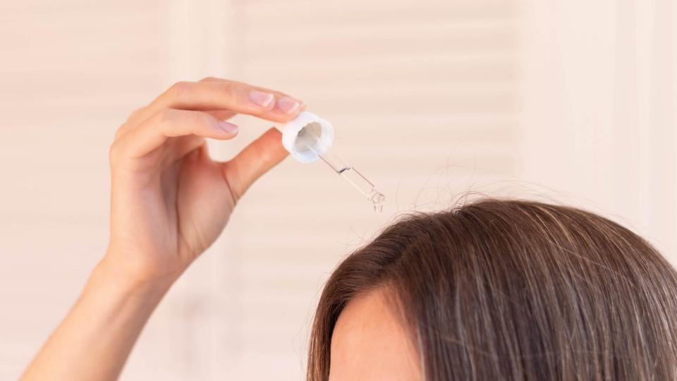 woman putting oil in her hair